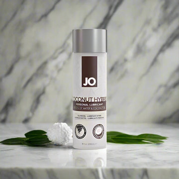 A bottle of JO Coconut Hybrid Original Lubricant with a white label and silver cap, prominently displaying the brand logo 'JO' at the top.